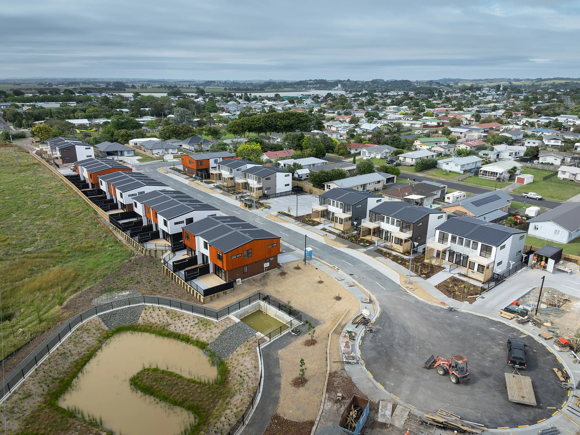 An aerial of the Dargaville terrace development, orange and white cladding along a new street